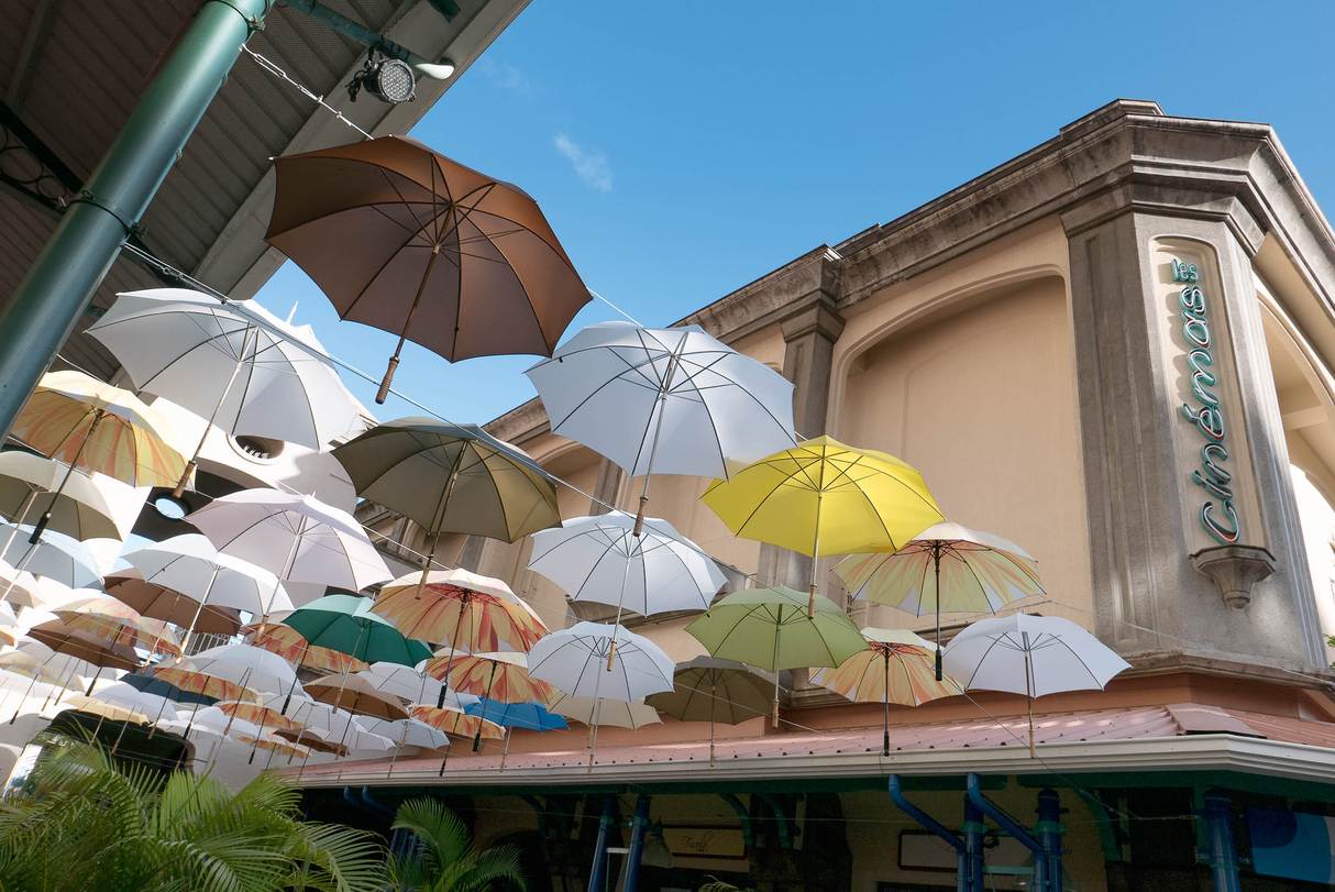 In einer Passage der am Yachthafen gelegenen Shoppingmall „Le Caudan Waterfront“ spenden bunte Schirme Schatten und schützen so vor der afrikanischen Sonne. Die Farben wechseln mit der Jahreszeit und zu besonderen Anlässen.