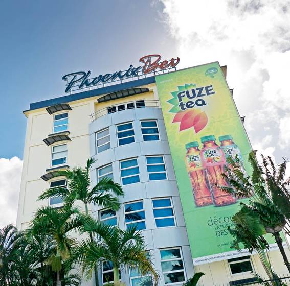 Großflächige Werbeplakate für das Coca-Cola-Produkt Fuze Tea zieren die Fassade der Hauptverwaltung von PhoenixBev auf Mauritius.