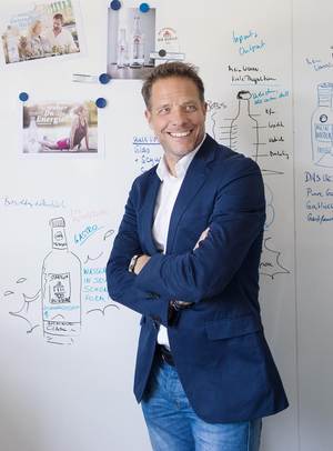 Stefan Brüggemann, Marketingleiter bei Bad Meinberger, vor Designskizzen für die neue Produktaus­stattung der Gastronomieprodukte des Unternehmens