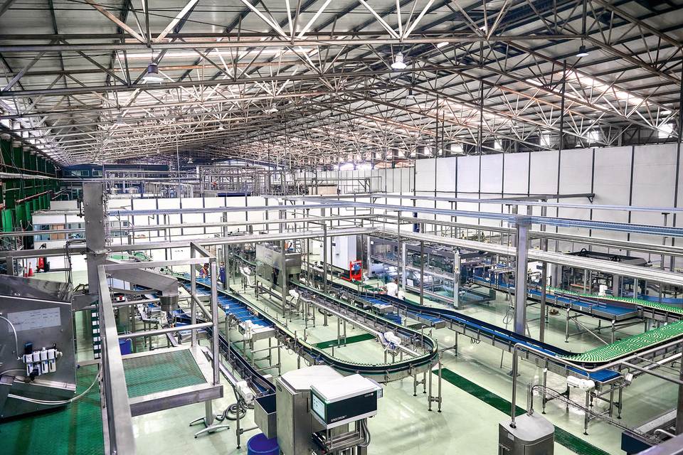 View of the line’s packaging section: in the center is the labeler, with the packer to the right and the conveyors with buffer segments in front of and between the two.