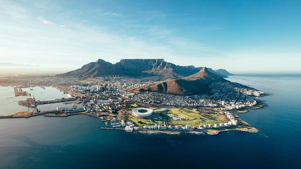 Am Fuß des beeindruckenden Tafelbergs breitet sich die südafrikanische Metropole Kapstadt mit ihrem geschäftigen Hafen und dem zur Fußball-WM 2010 fertiggestellten Stadion aus.