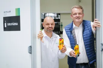 La imagen muestra a dos hombres, cada uno con una lata de refresco en la mano. El hombre de la izquierda es Tomáš Zahálka, director general de Bofillex, y el de la derecha, Lubomir Neubauer, director de ventas regional de KHS para la República Checa y Eslovaquia.