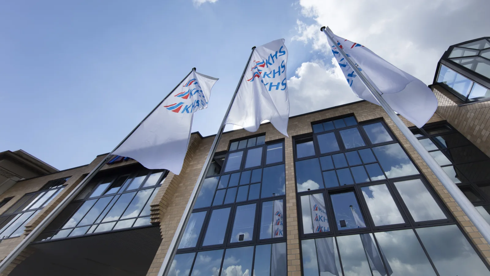 Three company flags fly in front of the Dortmund headquarters