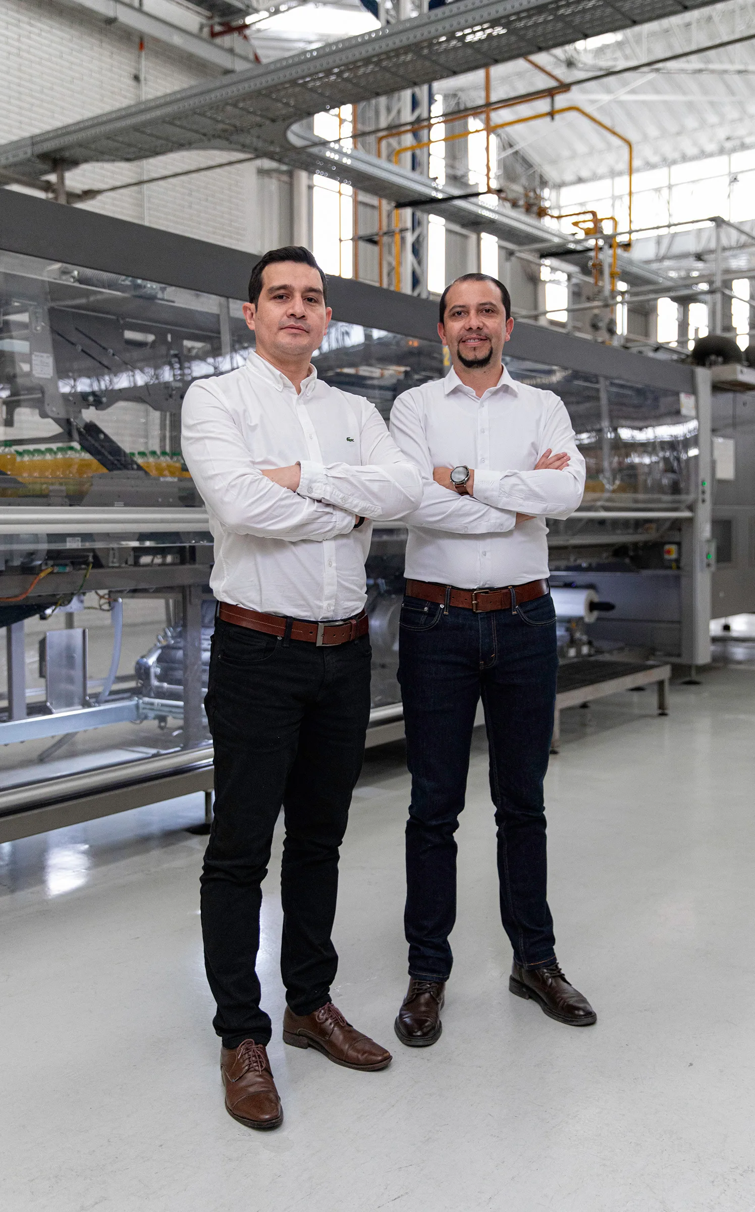Two men are standing in a factory hall.