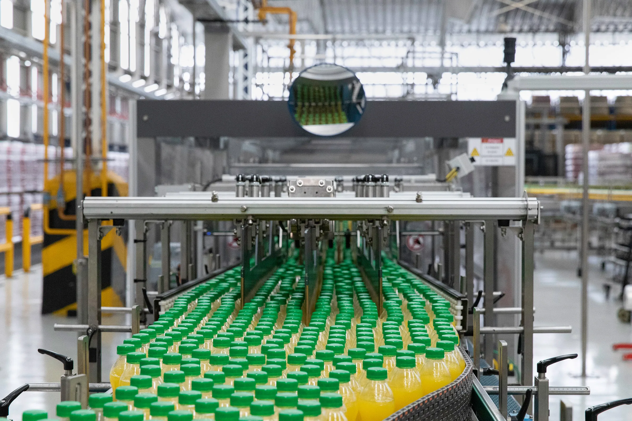 a conveyor belt with green bottles